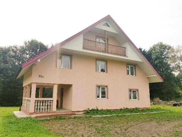 a large house with a balcony on top of it at Bieszczadzki dom nad stawem in Ropienka