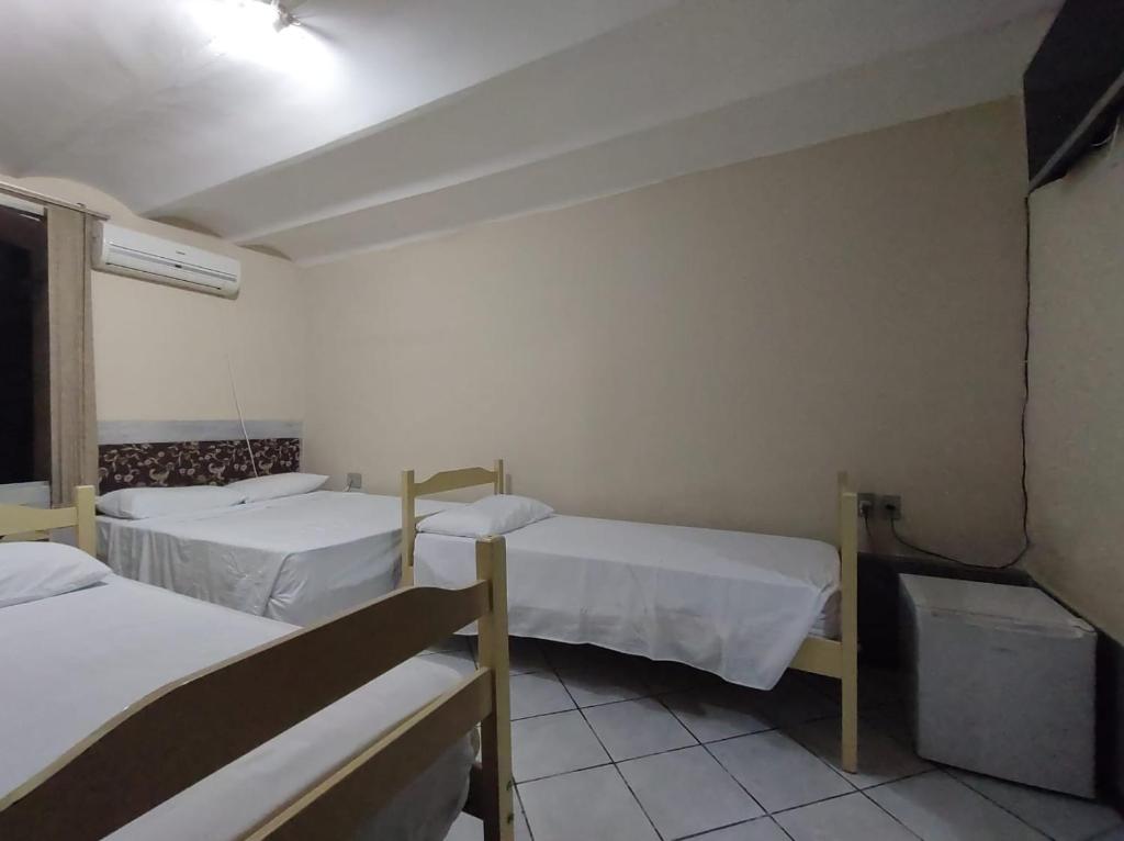 a room with two beds in a hospital room at Hotel Castelo in Santana do Livramento