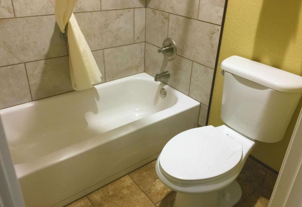 a bathroom with a white toilet and a tub and a sink at Howard Johnson by Wyndham Pigeon Forge in Pigeon Forge