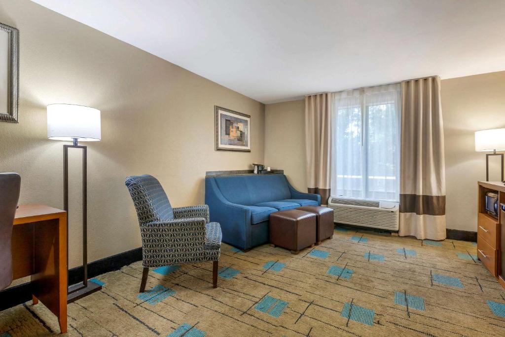 a living room with a blue couch and a chair at Comfort Suites near MCAS Beaufort in Beaufort