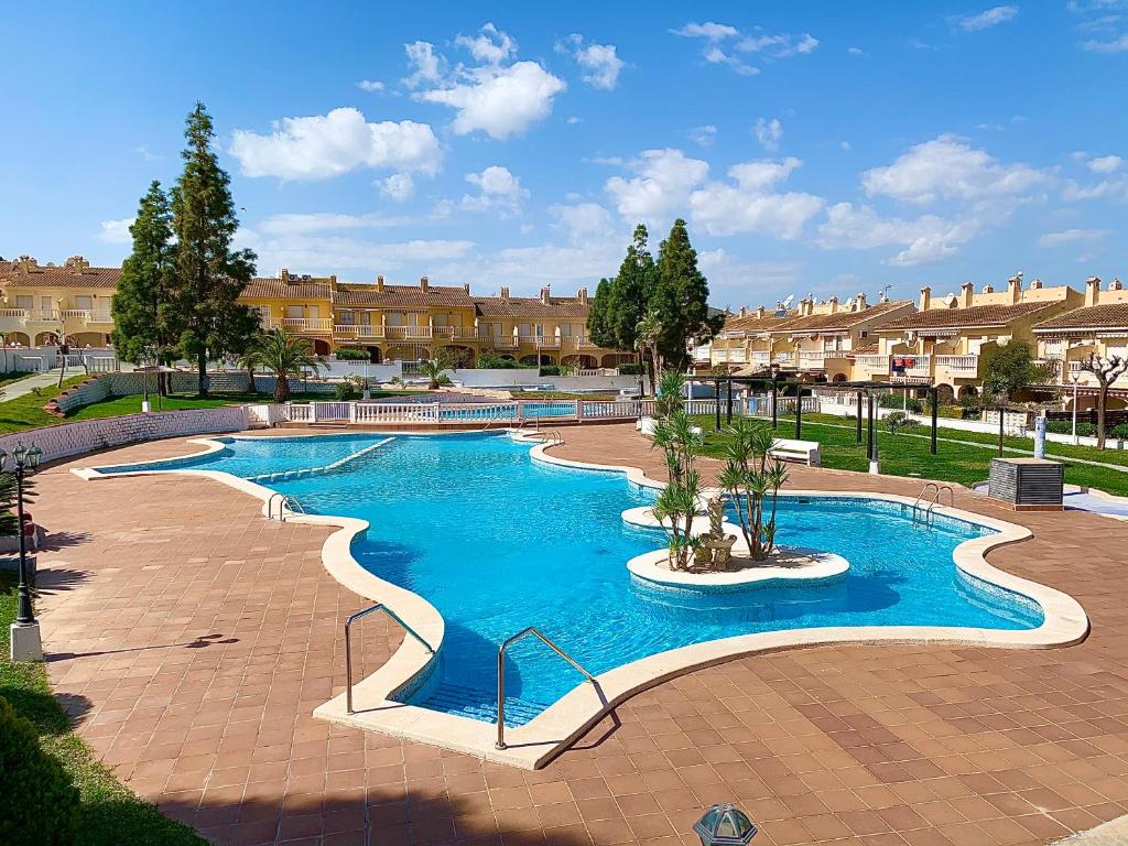 una grande piscina con acqua blu in un cortile di Villa Thierryanet ad Alicante