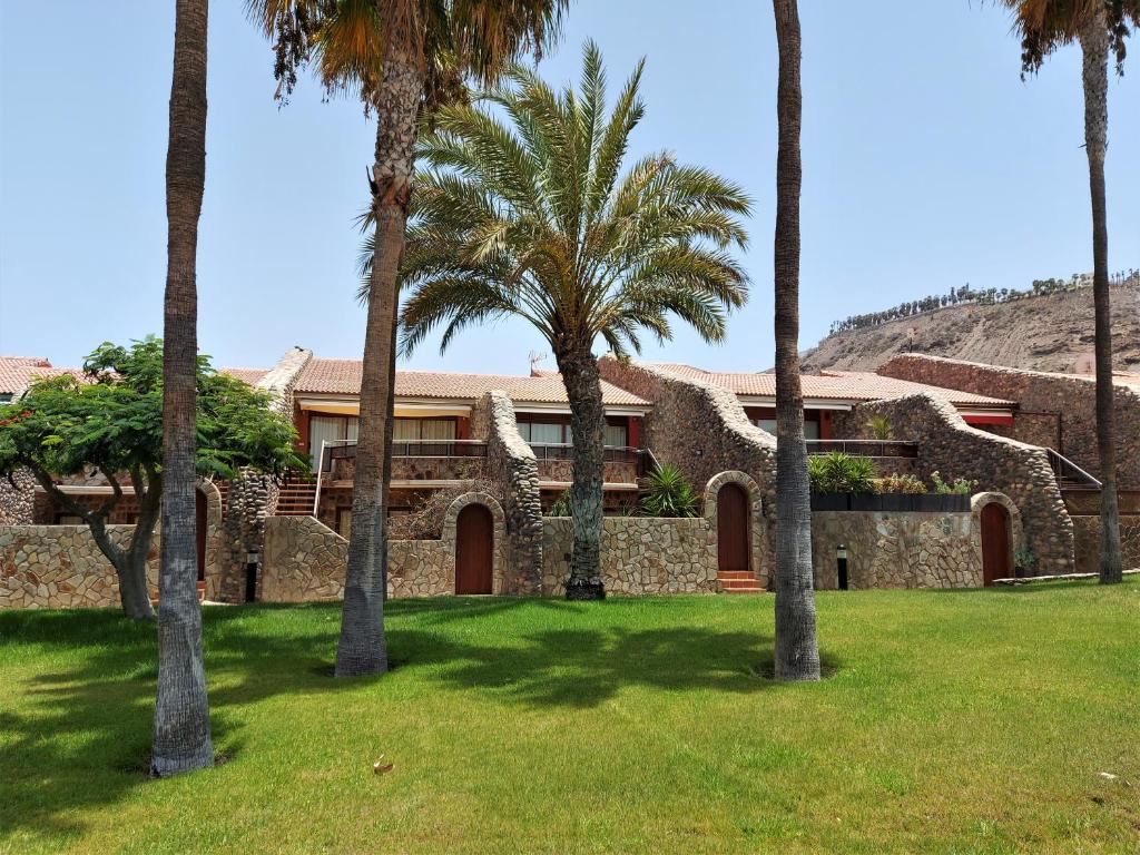 a house with palm trees in a yard at Casa Tauro Golf - Luxury chalet with sea view in Las Palmas de Gran Canaria