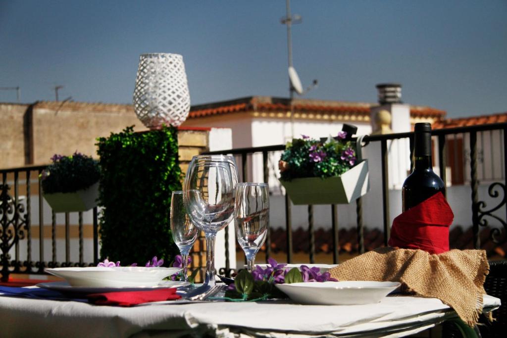 コルドバにあるBalcones De San Fernandoのグラスと皿、ワイン1本が備わるテーブル