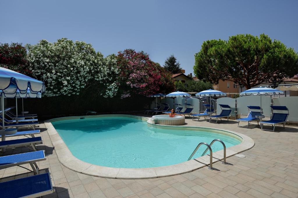 una grande piscina con sedie e ombrelloni di Hotel Gaston a Rimini