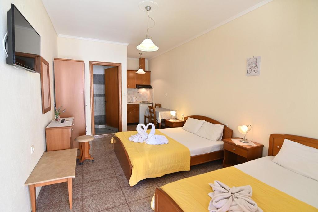 pokój hotelowy z dwoma łóżkami i telewizorem w obiekcie villa panorama w mieście Asprovalta