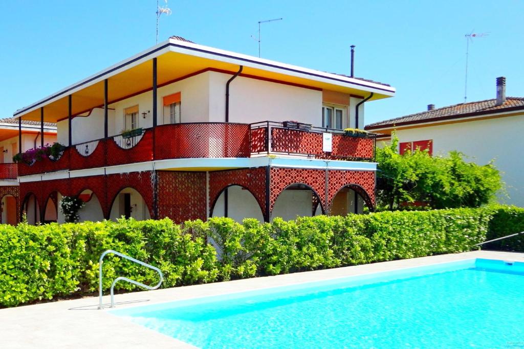 un edificio con piscina frente a una casa en Spacious villa with private garden and pool, en Porto Santa Margherita