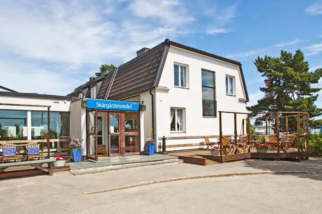 a white building with chairs in front of it at Skärgårdshotellet in Nynäshamn