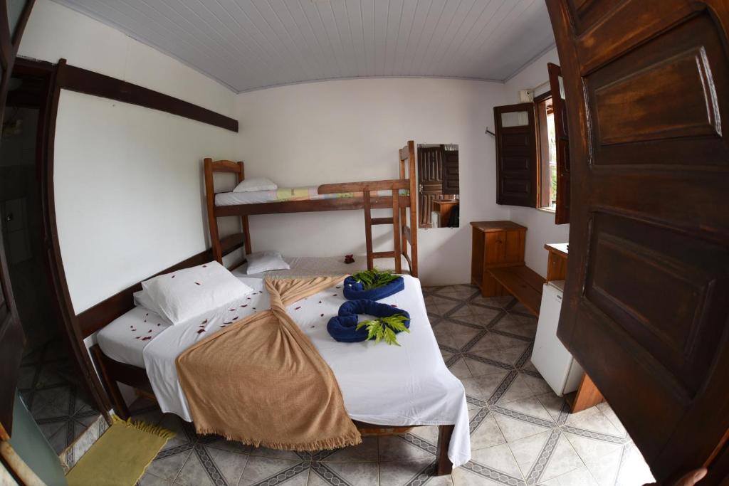 una piccola stanza con due letti e un tavolo di Pico das Praias Suites a Itacaré