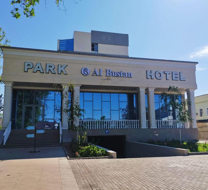 un bâtiment avec un parc et un hôtel fragile dans l'établissement Park Hotel al Bustan, à Chimkent