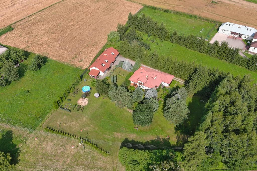 an aerial view of a farm with a house and trees at Świerkowe Wzgórze in Grabków