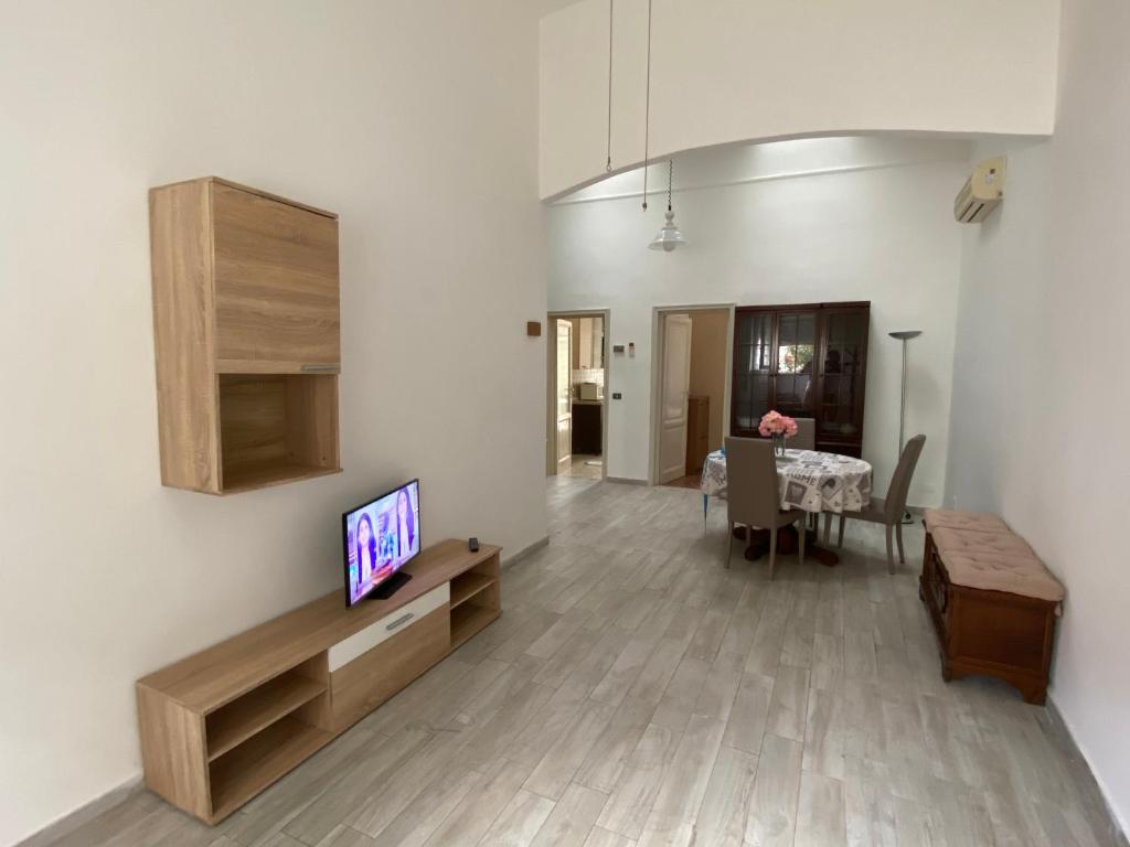 ein Wohnzimmer mit einem TV und einem Esstisch in der Unterkunft La casa del pescatore in Viareggio