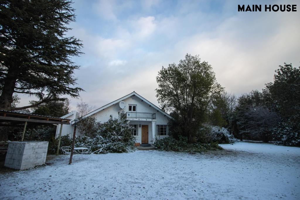 una casa con nieve en el suelo delante de ella en JAYA'S PLACE, en Hogsback