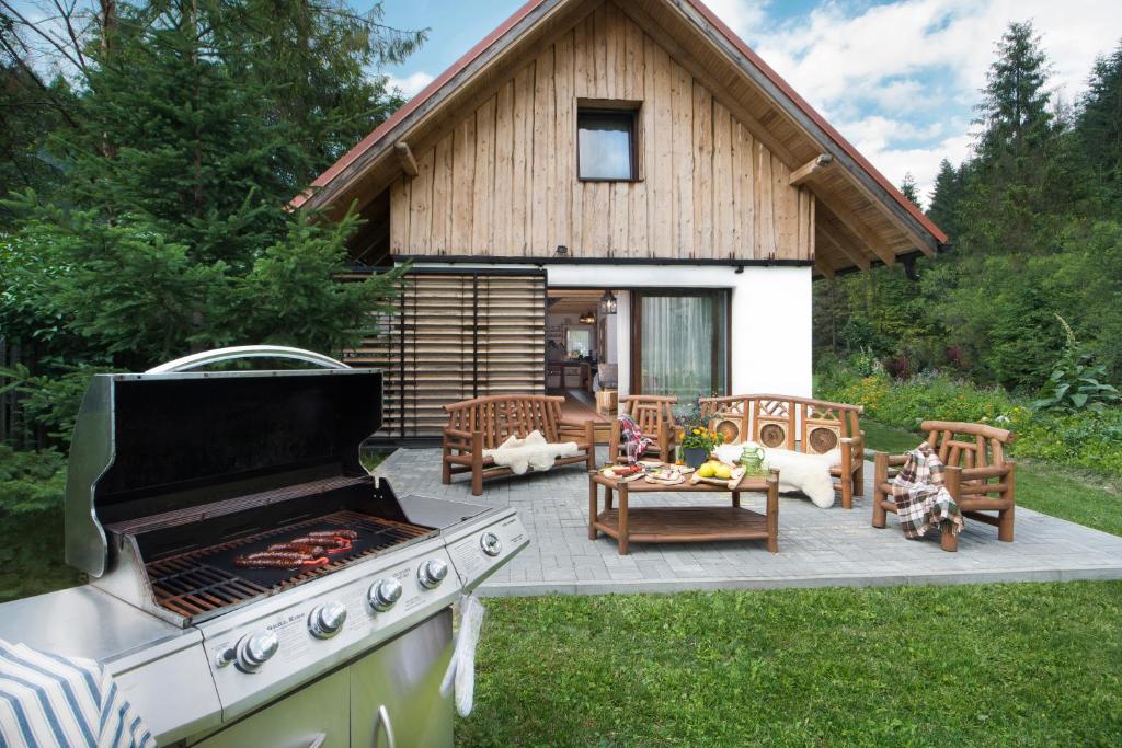 eine Terrasse im Hinterhof mit einem Grill und einem Haus in der Unterkunft CHATAUDEDKA sk in Hrabušice