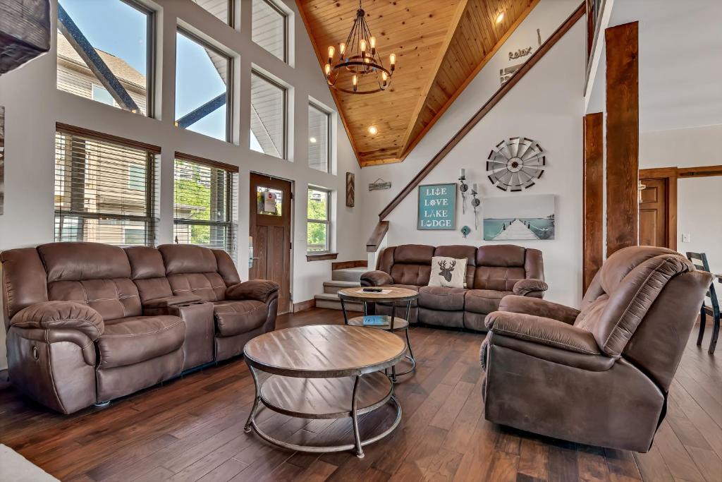 a living room with leather furniture and a table at Rockwood Lake Lodge home in Branson