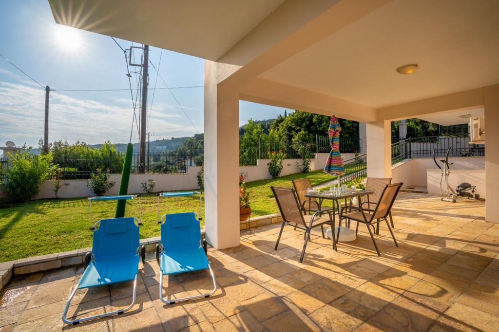 a patio with a table and chairs on a patio at Paralia Platanou seaview house in Paralía Platánou