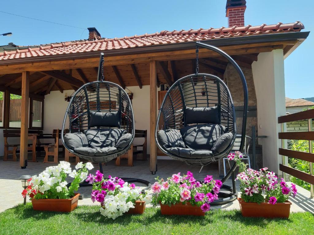 two wicker chairs hanging from a gazebo at Къща за гости Романс in Yagodina