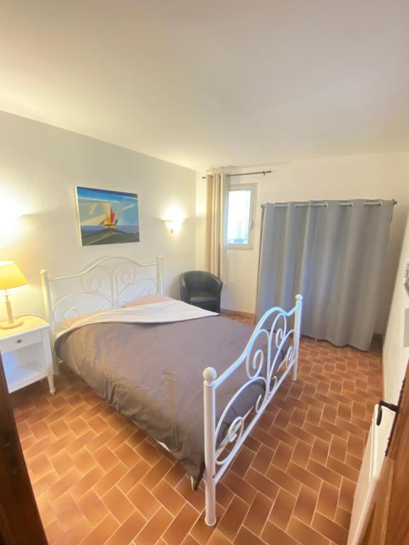 1 dormitorio con 1 cama y 1 silla en Charmant appartement au cœur du village, en Tourrettes-sur-Loup