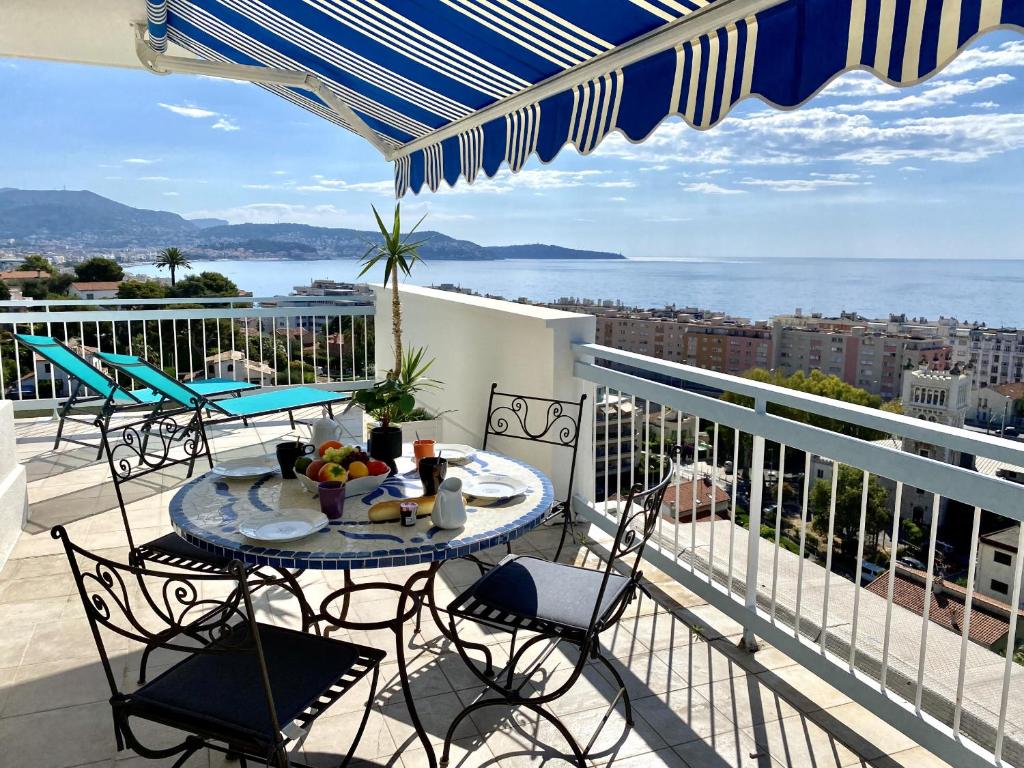 a balcony with chairs and a table with fruit on it at VUE DES ANGES AP4238 By Riviera Holiday Homes in Nice