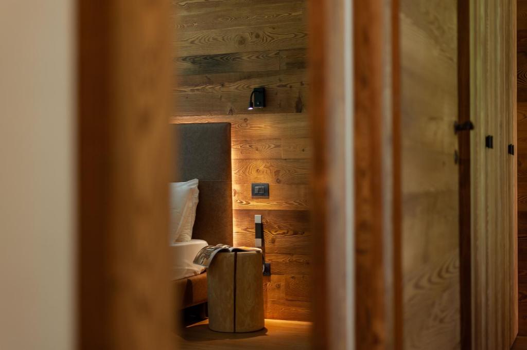 a room with a suitcase in front of a bed at Orobie Alps Resort in Roncobello