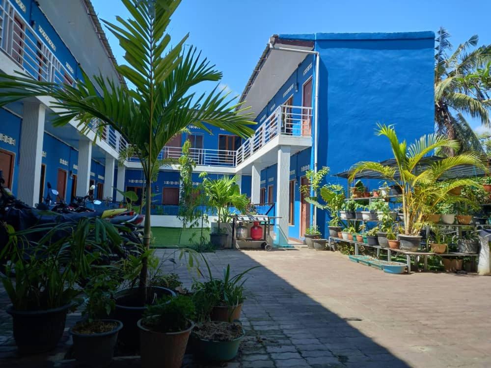 una calle con palmeras frente a un edificio en Gama Apartments en Dili