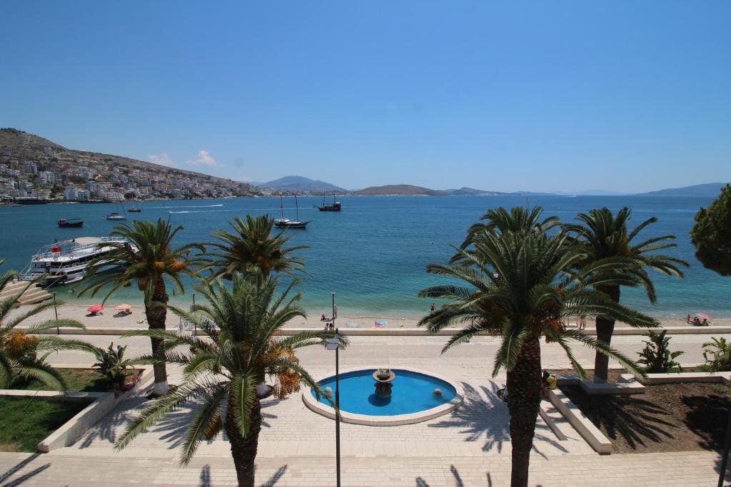 a view of a beach with palm trees and the ocean at Hotel Ari in Sarandë