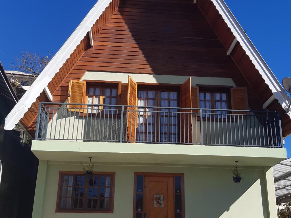 a house with a balcony on top of it at SILVÉRIOS Suítes DA MONTANHA in Campos do Jordão