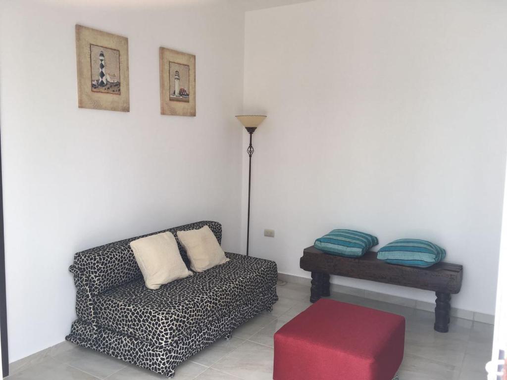 a living room with a couch and a red stool at Casa Bella-suit in Ciudadela Costa de Oro