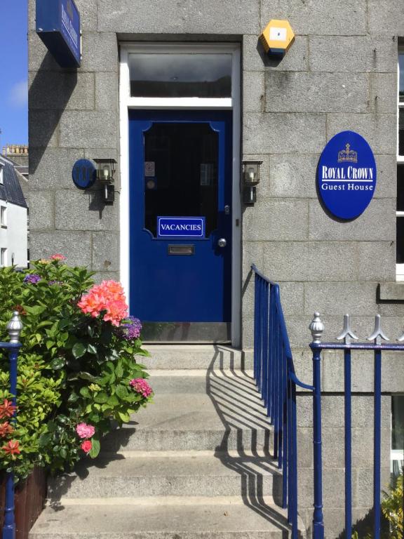 uma porta azul num edifício com um sinal em The Royal Crown Guest House em Aberdeen