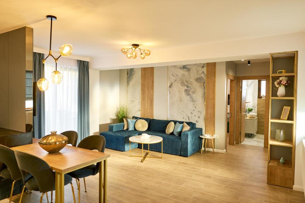 a living room with a blue couch and a table at EEE Apart Boutique in Constanţa