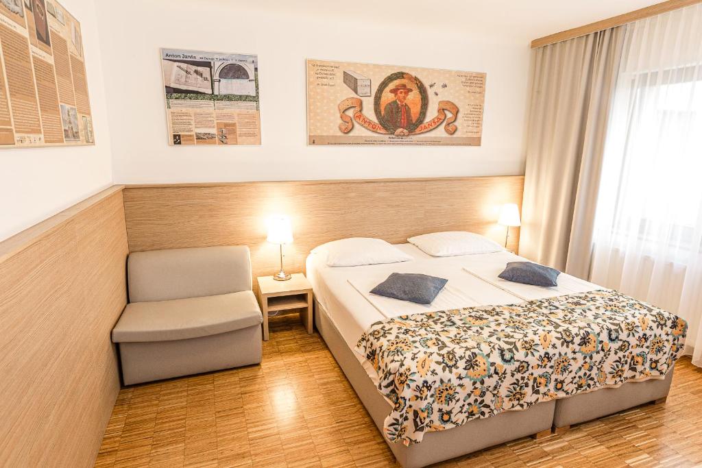 una habitación de hotel con una cama y una silla en Hotel Korotan, en Viena