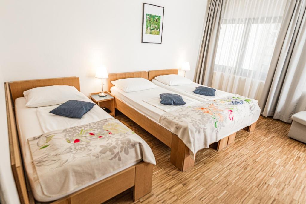 a bedroom with two beds and a window at Hotel Korotan in Vienna