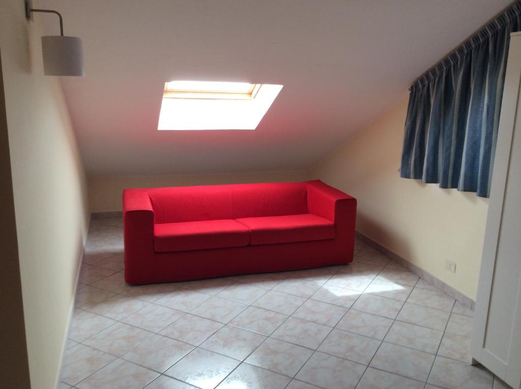a red couch in a room with a skylight at Casa Vacanze Samira in Fondachello