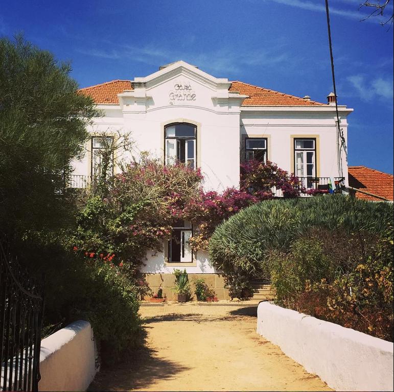 una casa blanca con techo rojo y algunos arbustos en Casa Grande Portugal en Burgau