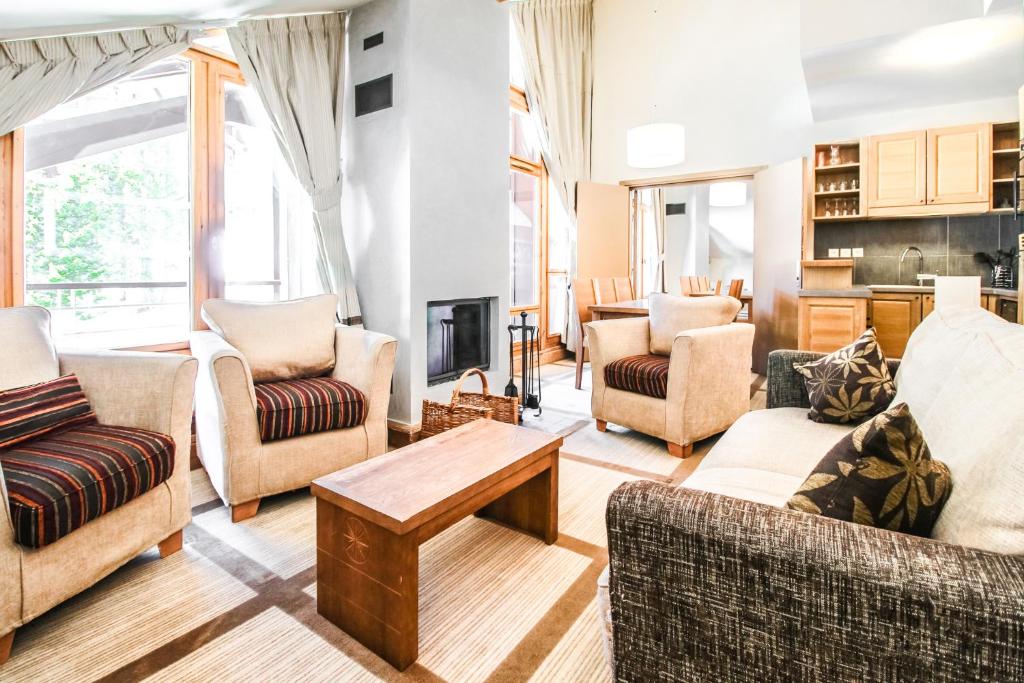 a living room with couches and a table at Two internally connecting 2-bed apartments with shared private entrance in Flaine