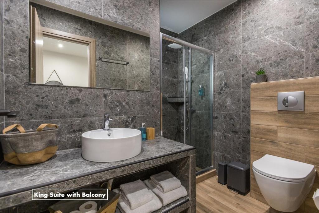 ein Badezimmer mit einem Waschbecken, einem WC und einem Spiegel in der Unterkunft Athens Raise Acropolis Project in Athen