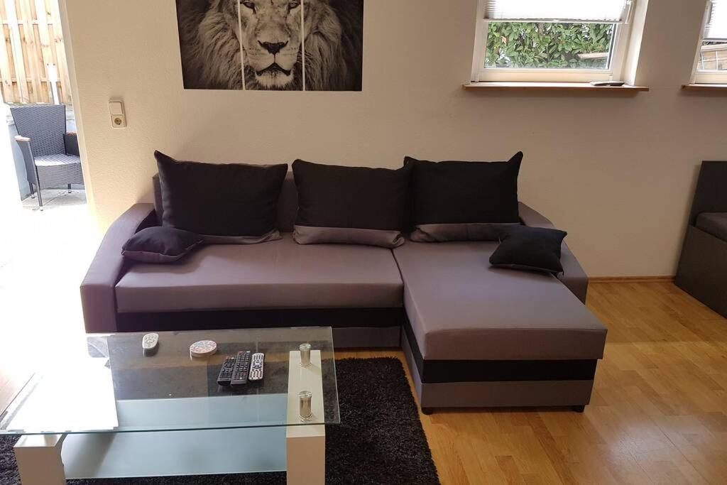 - un canapé dans le salon orné d'une peinture sur lion sur le mur dans l'établissement Schöne Wohnung in Karben - Rendel, mit Freisitz, à Karben