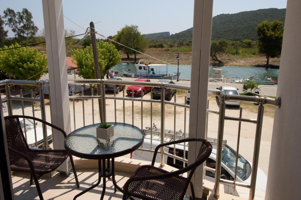 uma mesa e cadeiras numa varanda com vista para uma marina em Golden Sand em Ammoudia