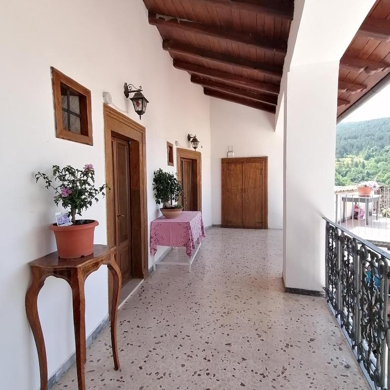 a hallway of a house with a table and flowers at Piazzetta Del Forno - Monolocale in Assergi