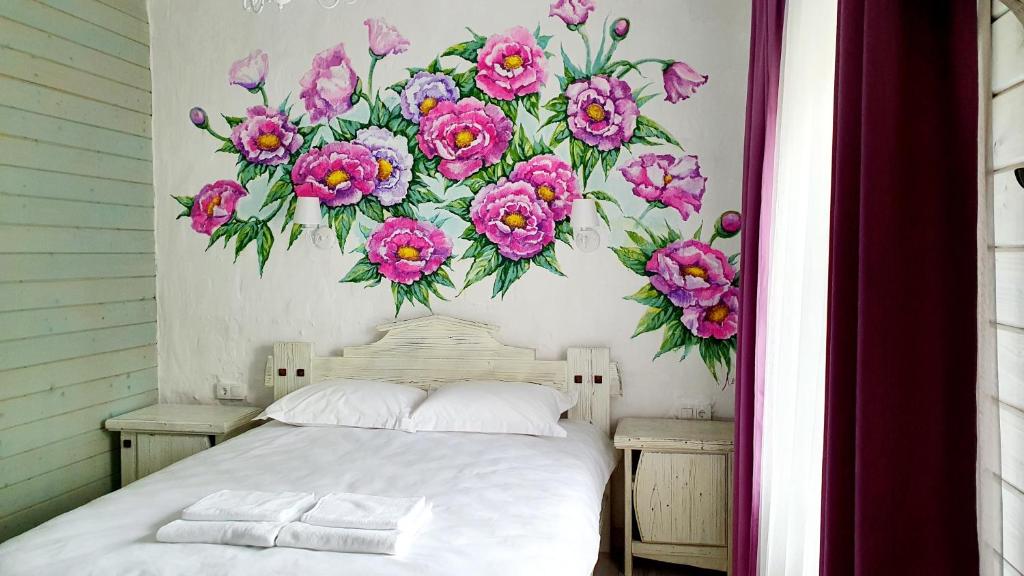 a bedroom with a flower mural on the wall at Olko House in Yaremche
