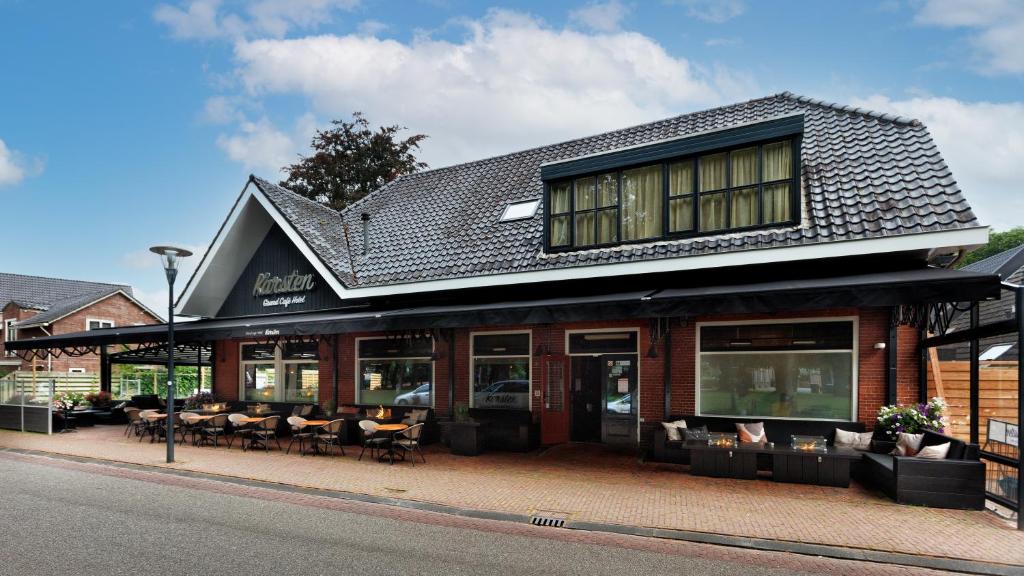 a building with chairs and tables on a street at Hotel Karsten in Norg
