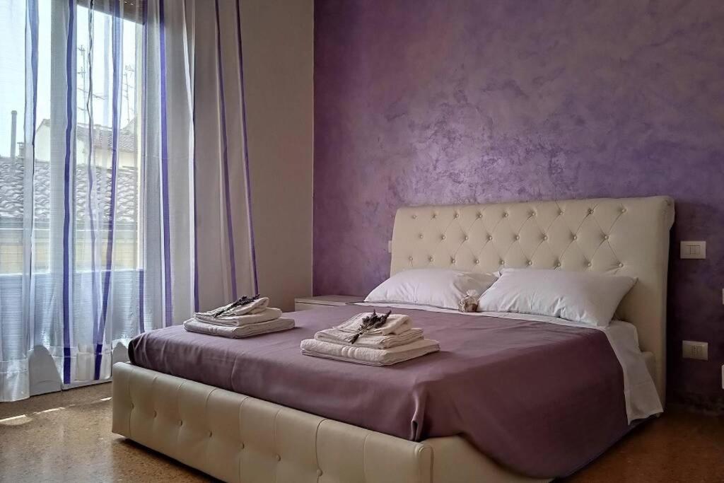 um quarto com uma cama grande e paredes roxas em CasaGiorgio a due passi dal centro storico em Florença