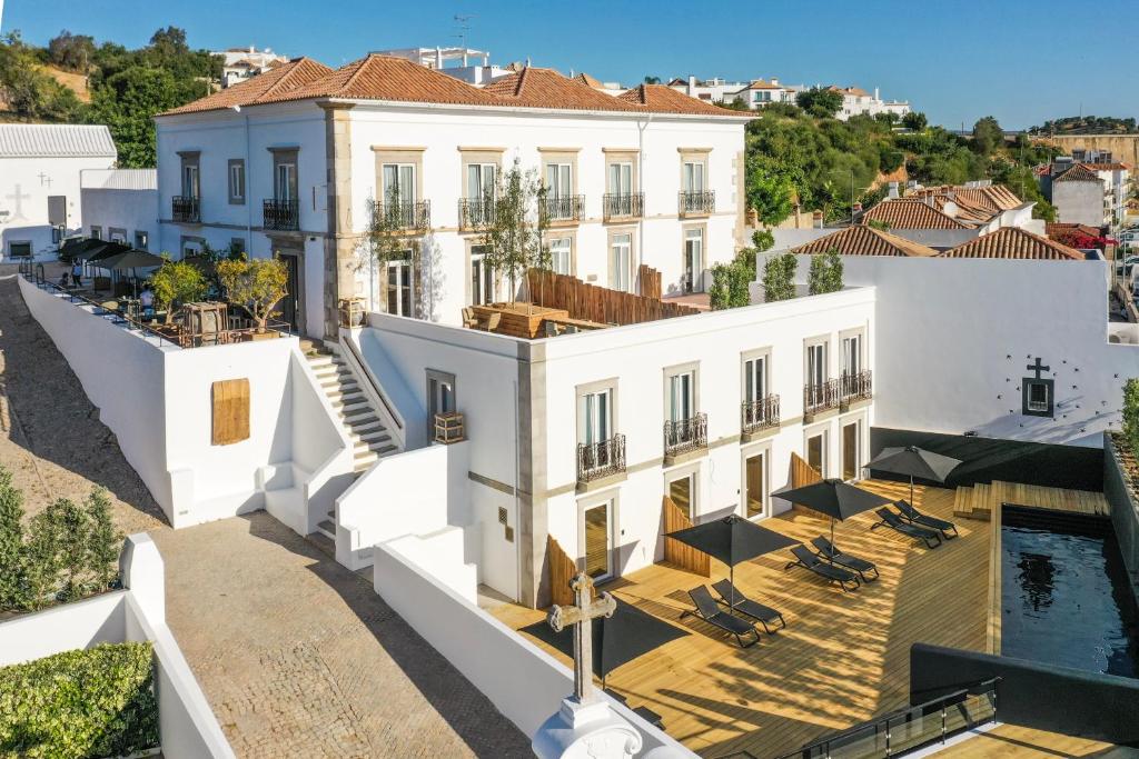 eine Luftansicht auf ein weißes Gebäude mit einem Pool in der Unterkunft Colégio Charm House in Tavira