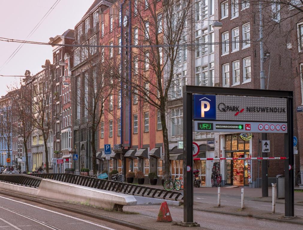 eine Stadtstraße mit hohen Gebäuden und einem Parkschild in der Unterkunft WestCord City Centre Hotel in Amsterdam
