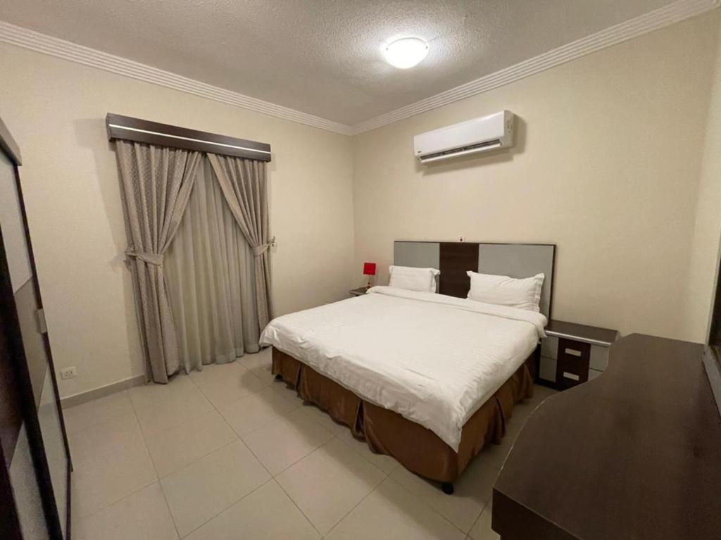 ein Schlafzimmer mit einem großen Bett und einem Fenster in der Unterkunft Al-Fakhamah Hotel Apartments - Families Only in Khobar