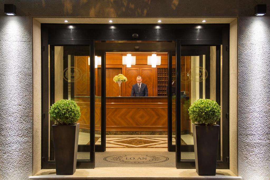 a man standing in the entrance to a building at Hotel Santa Costanza by OMNIA hotels in Rome