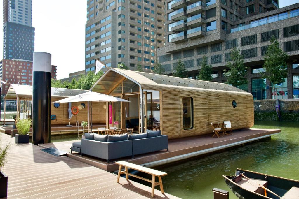 een klein huis op een dok in het water bij Wikkelboats at Floating Rotterdam Rijnhaven in Rotterdam