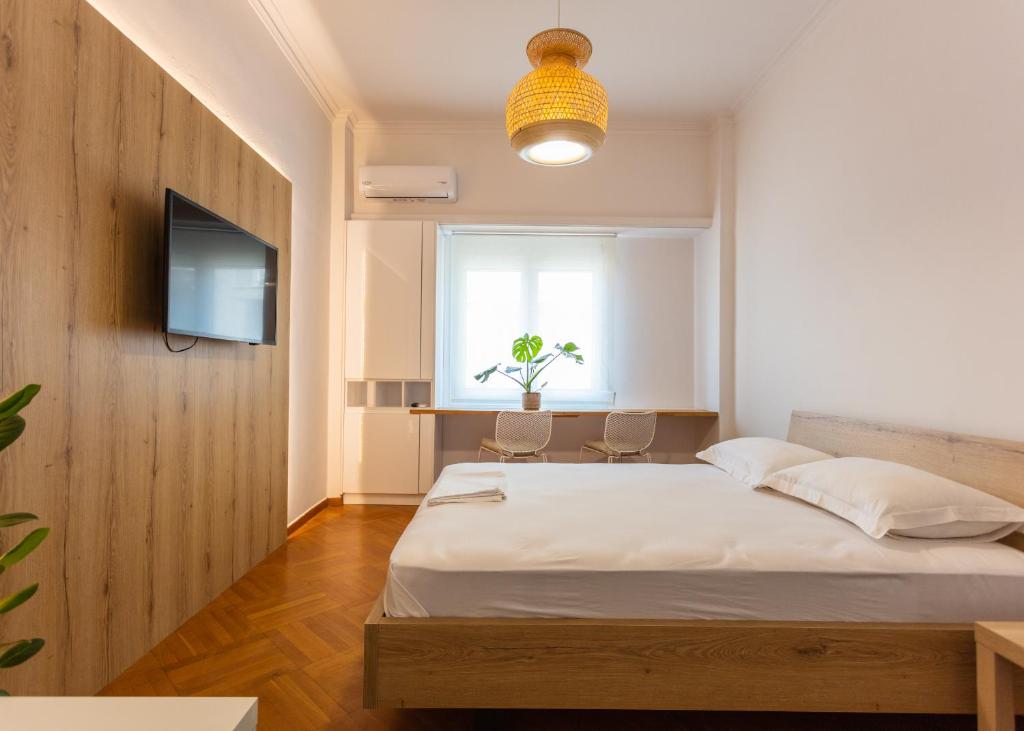 a bedroom with a bed and a tv and a window at Bridge Studio in Chalkida