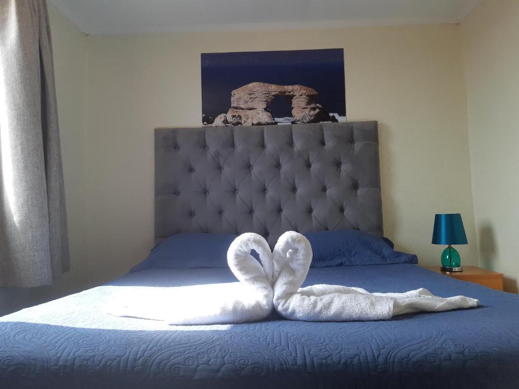 a bed with a white towel in the shape of a heart at Bellissa House in Antofagasta