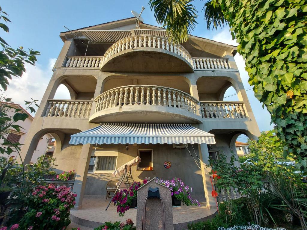 a building with a balcony on the side of it at Apartman Palma in Rijeka