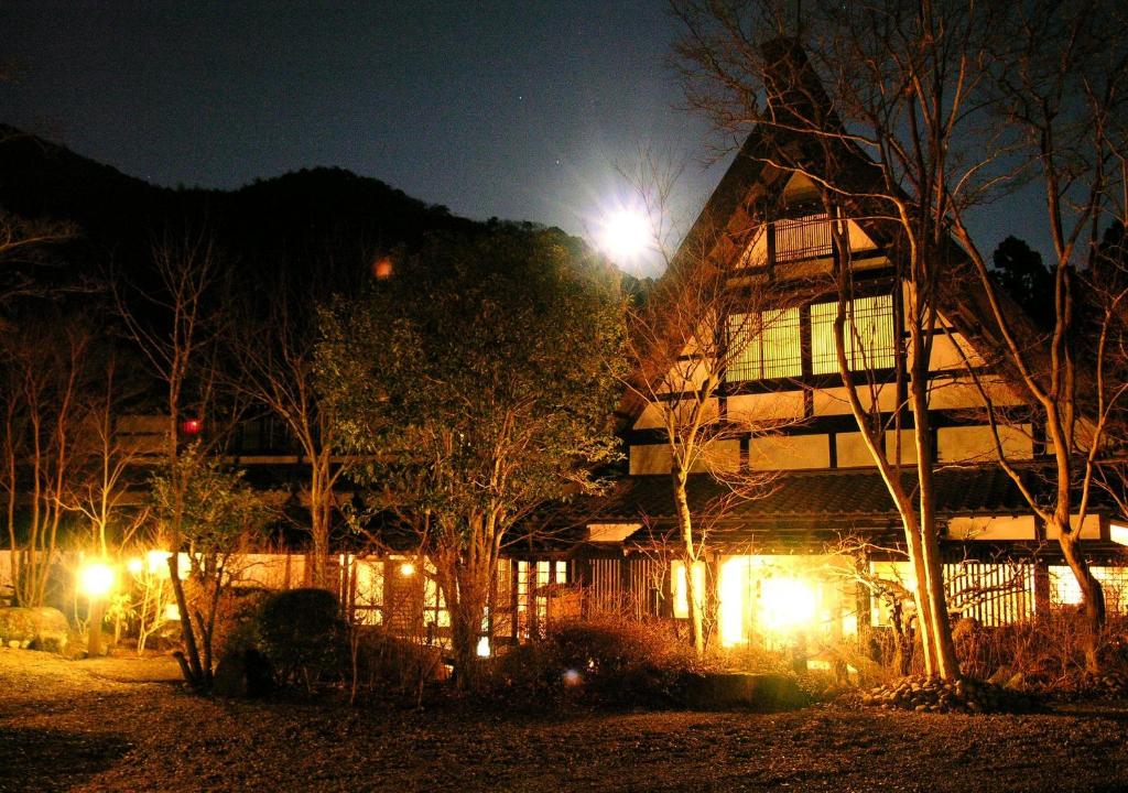 un edificio con una luz delante de él por la noche en Hazu Gassyo, en Shinshiro